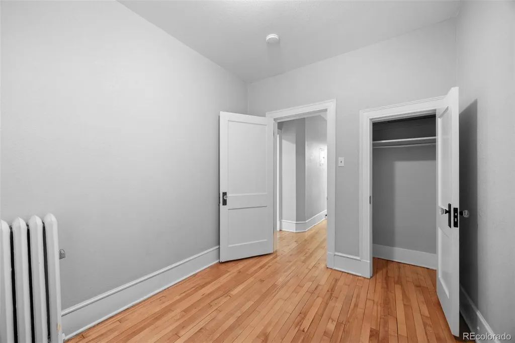 Second bedroom with a closet, radiator and hardwood floors